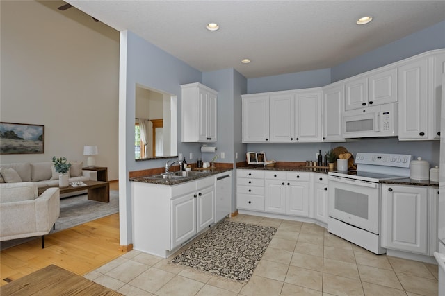 1201 NW Norton St, Grimes, IA 50111 - kitchen with white appliances, white cabinets, light tile patterned floors, recessed lighting, and dark stone countertops