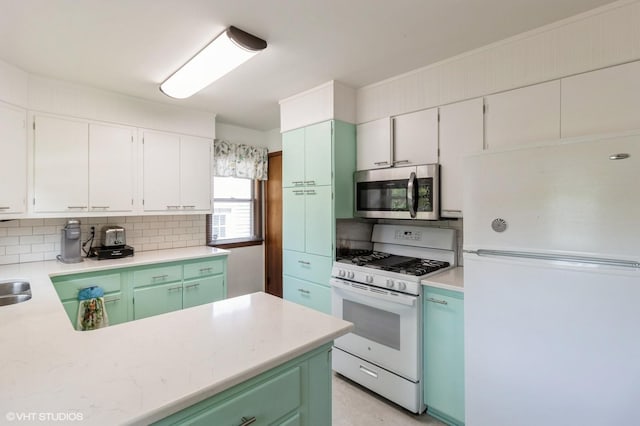 3709 Aurora Ave, Des Moines, IA 50310 - kitchen featuring white appliances, tasteful backsplash, light countertops, green cabinets, and white cabinetry