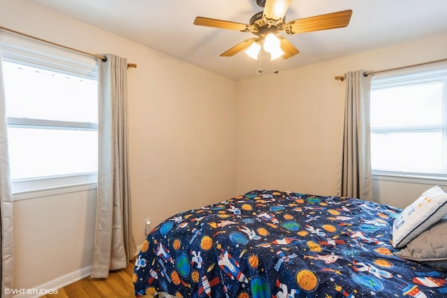 3709 Aurora Ave, Des Moines, IA 50310 - bedroom featuring multiple windows, wood finished floors, and a ceiling fan