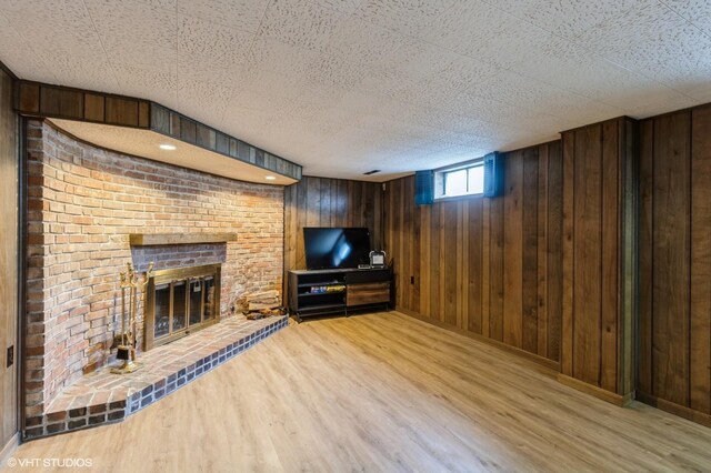 3709 Aurora Ave, Des Moines, IA 50310 - unfurnished living room featuring wood finished floors, wooden walls, and a fireplace