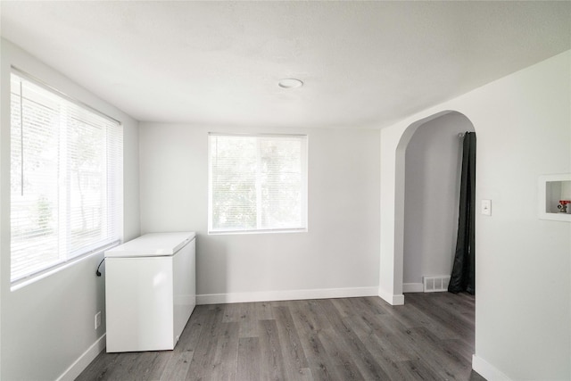 6325 NW 56th St, Johnston, IA 50131 - spare room featuring arched walkways and wood finished floors