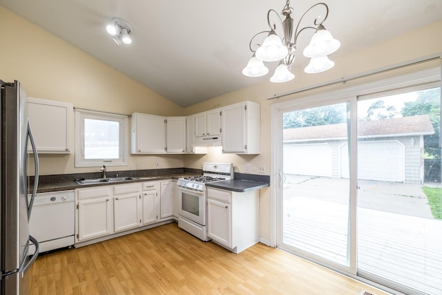 2316 SE 17th St, Des Moines, IA 50320 - kitchen with white appliances, under cabinet range hood, dark countertops, a chandelier, and lofted ceiling