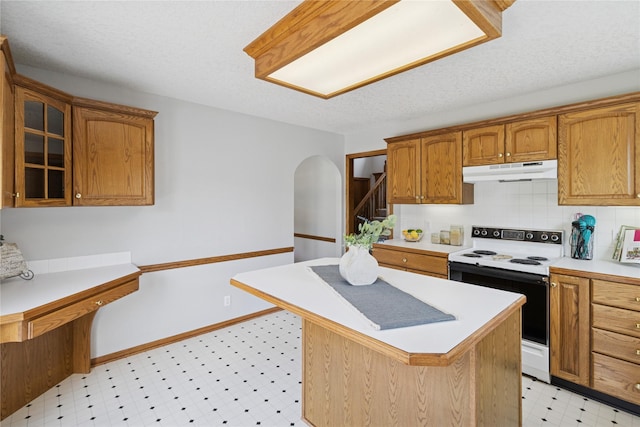 8001 Sheridan Dr, Urbandale, IA 50322 - kitchen with white range with electric stovetop, under cabinet range hood, light flooring, light countertops, and arched walkways