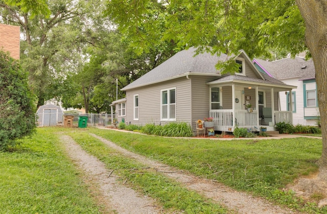 420 9th St, West Des Moines, IA 50265 - bungalow-style house featuring covered porch, a shingled roof, a storage unit, and driveway