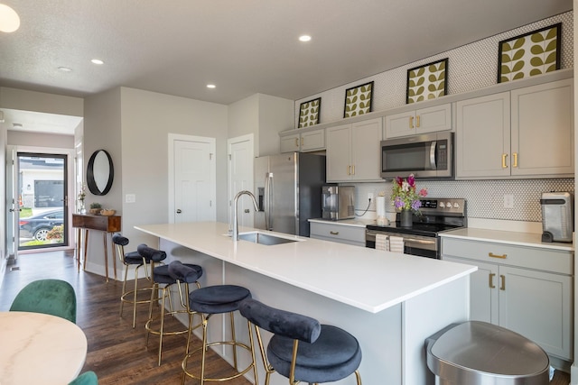 1504 NE Savana Dr, Grimes, IA 50111 - kitchen featuring stainless steel appliances, a center island with sink, dark wood-style floors, gray cabinets, and recessed lighting