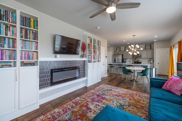 1504 NE Savana Dr, Grimes, IA 50111 - living area featuring a chandelier, dark wood-type flooring, ceiling fan, a glass covered fireplace, and recessed lighting