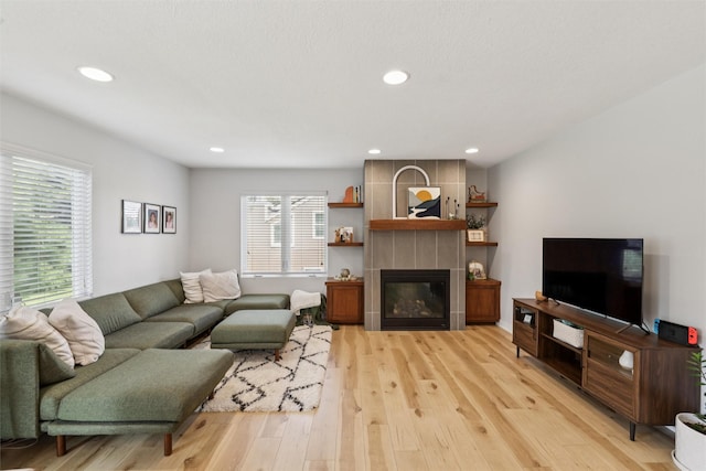 8113 Hammontree Cir, Urbandale, IA 50322 - living area with light wood finished floors, a tile fireplace, and recessed lighting