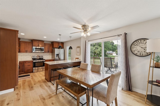 8113 Hammontree Cir, Urbandale, IA 50322 - dining room with light wood finished floors, ceiling fan, and recessed lighting