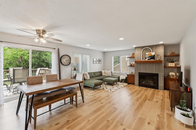 8113 Hammontree Cir, Urbandale, IA 50322 - dining area with light wood-style floors, a fireplace, ceiling fan, and recessed lighting