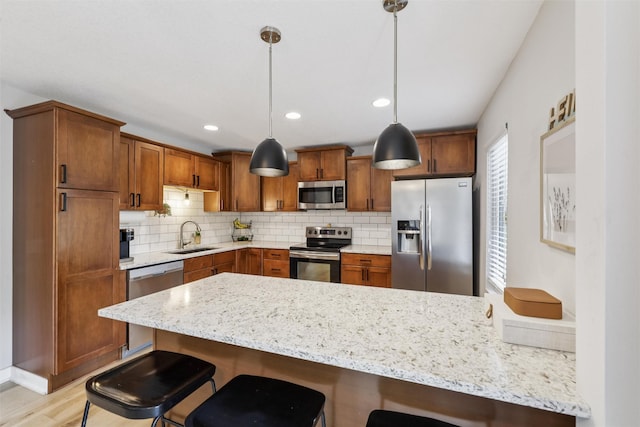 8113 Hammontree Cir, Urbandale, IA 50322 - kitchen featuring appliances with stainless steel finishes, a peninsula, a kitchen bar, backsplash, and brown cabinetry