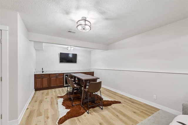 8113 Hammontree Cir, Urbandale, IA 50322 - dining room featuring light wood-type flooring and a textured ceiling
