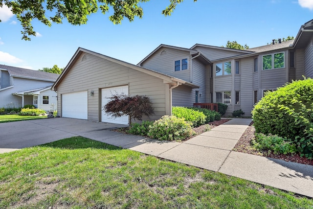 4719 84th St Unit A, Urbandale, IA 50322 - view of front facade with concrete driveway, an attached garage, and a front lawn