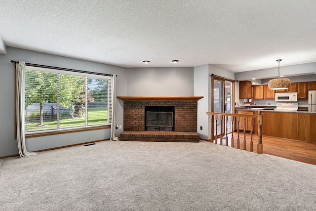 4719 84th St Unit A, Urbandale, IA 50322 - unfurnished living room featuring light carpet, a textured ceiling, and a fireplace