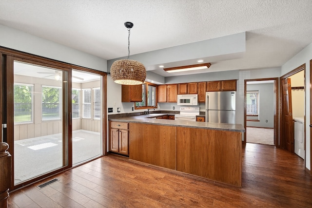 4719 84th St Unit A, Urbandale, IA 50322 - kitchen with white appliances, dark wood-type flooring, brown cabinetry, recessed lighting, and a textured ceiling