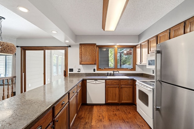 4719 84th St Unit A, Urbandale, IA 50322 - kitchen with white appliances, brown cabinets, recessed lighting, a textured ceiling, and healthy amount of natural light