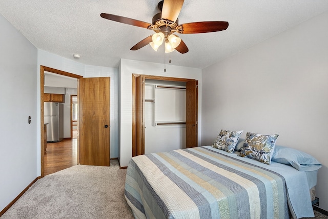 4719 84th St Unit A, Urbandale, IA 50322 - bedroom featuring freestanding refrigerator, light carpet, a closet, and a ceiling fan