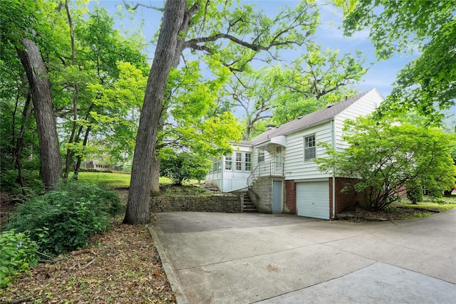 2625 38th St, Des Moines, IA 50310 - view of side of property featuring stairs, concrete driveway, and an attached garage