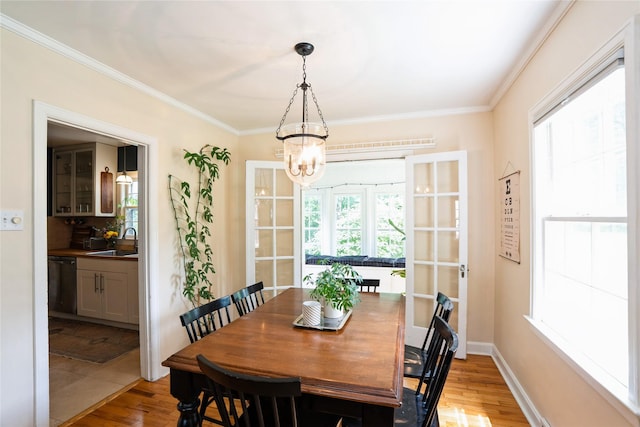 2625 38th St, Des Moines, IA 50310 - dining area featuring a chandelier, light wood finished floors, and crown molding