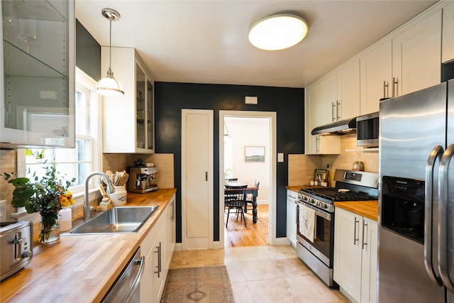 2625 38th St, Des Moines, IA 50310 - kitchen featuring butcher block counters, appliances with stainless steel finishes, white cabinets, and backsplash