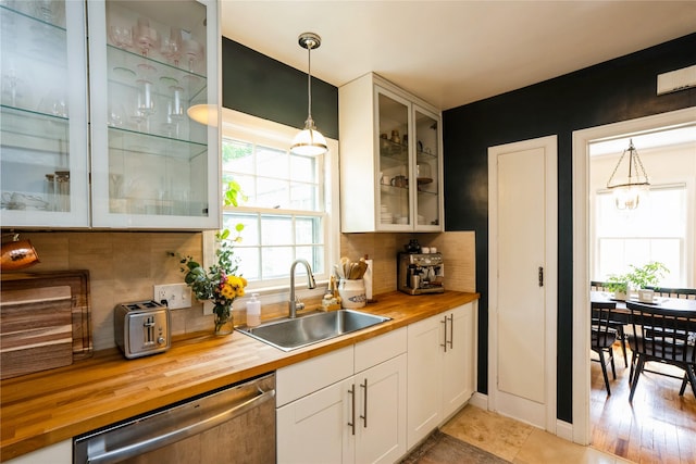 2625 38th St, Des Moines, IA 50310 - kitchen with wooden counters, stainless steel dishwasher, backsplash, glass insert cabinets, and white cabinets