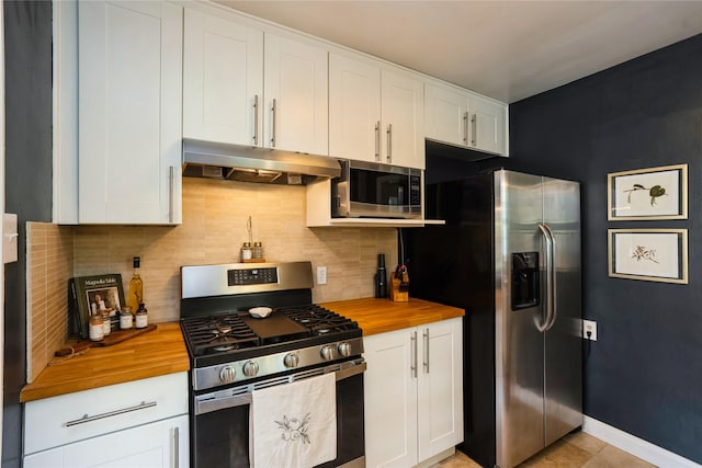 2625 38th St, Des Moines, IA 50310 - kitchen featuring stainless steel appliances, wood counters, under cabinet range hood, and backsplash