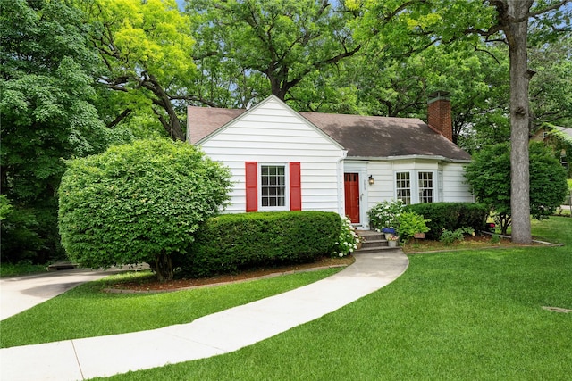 2625 38th St, Des Moines, IA 50310 - view of front of home featuring roof with shingles, a chimney, and a front yard