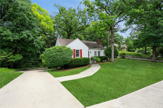 2625 38th St, Des Moines, IA 50310 - view of front of house with a chimney, a front lawn, and concrete driveway
