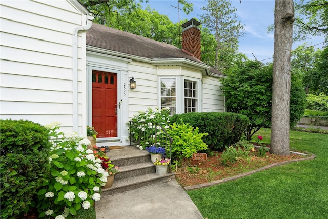 2625 38th St, Des Moines, IA 50310 - view of exterior entry featuring a lawn and a chimney