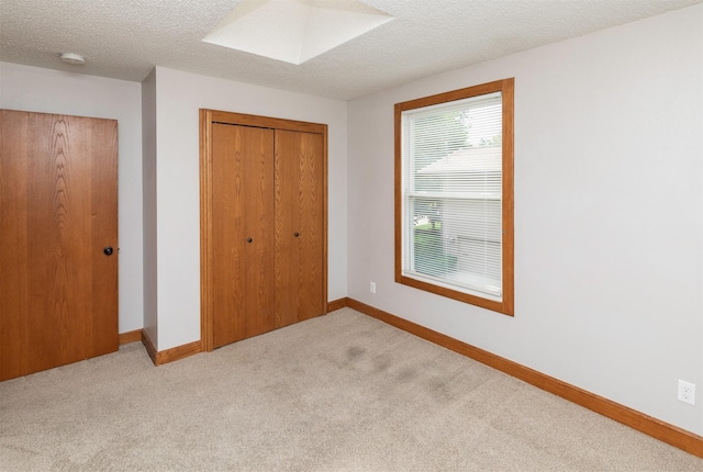 3948 43rd St, Des Moines, IA 50310 - unfurnished bedroom featuring a closet, light carpet, and a textured ceiling
