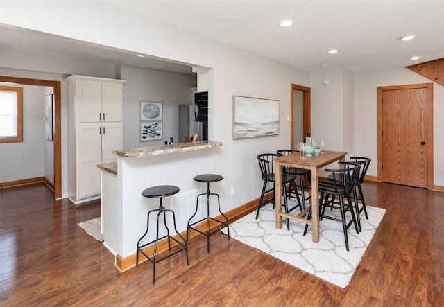 3948 43rd St, Des Moines, IA 50310 - dining area featuring dark wood-style flooring, recessed lighting, and a textured ceiling