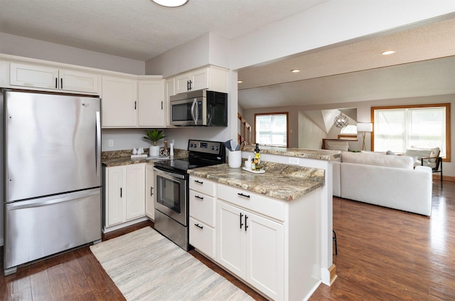 3948 43rd St, Des Moines, IA 50310 - kitchen featuring stainless steel appliances, a peninsula, light wood finished floors, white cabinets, and recessed lighting