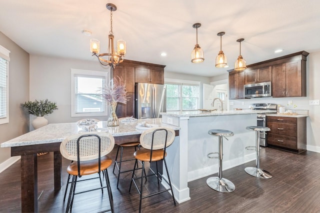 3817 80th St, Urbandale, IA 50322 - kitchen with appliances with stainless steel finishes, a large island with sink, dark wood-type flooring, recessed lighting, and a breakfast bar area