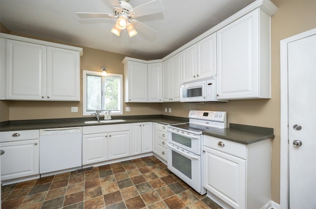 2418 Terrace Rd, Des Moines, IA 50312 - kitchen with white appliances, dark countertops, stone finish floors, white cabinets, and a ceiling fan
