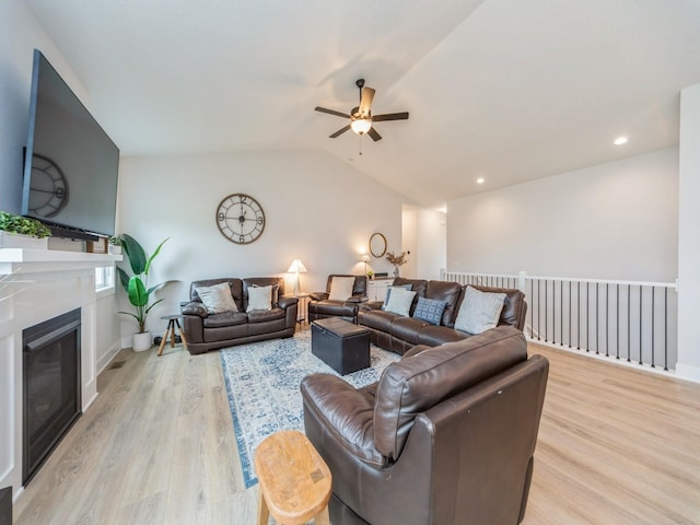 645 NW Prairie Rose Ln, Waukee, IA 50263 - living room with a ceiling fan, light wood-style flooring, vaulted ceiling, a glass covered fireplace, and recessed lighting