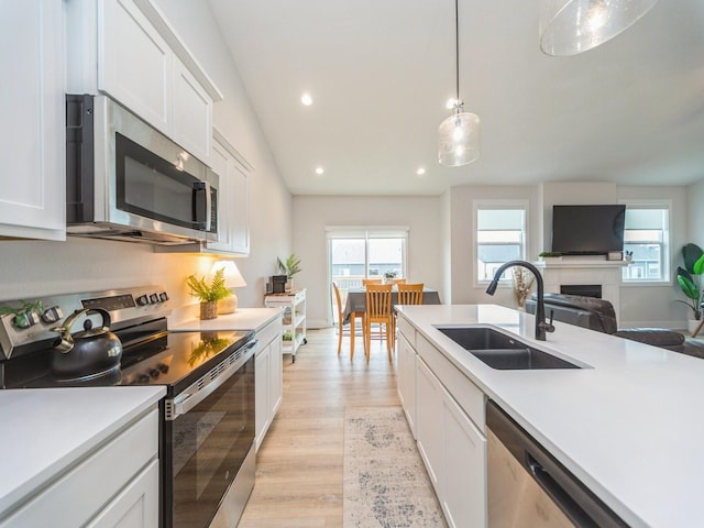 645 NW Prairie Rose Ln, Waukee, IA 50263 - kitchen featuring appliances with stainless steel finishes, recessed lighting, light wood finished floors, light countertops, and white cabinetry