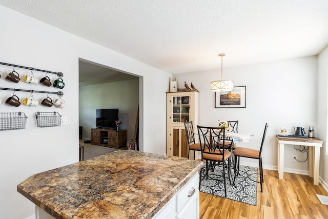 276 NW Georgetown Blvd, Ankeny, IA 50023 - kitchen featuring light wood-style floors, white cabinets, pendant lighting, a textured ceiling, and dark countertops