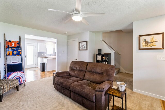 276 NW Georgetown Blvd, Ankeny, IA 50023 - living room featuring light colored carpet, ceiling fan, stairs, and a textured ceiling