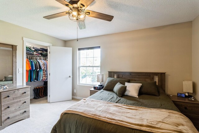 276 NW Georgetown Blvd, Ankeny, IA 50023 - bedroom with light colored carpet, ceiling fan, a closet, a walk in closet, and a textured ceiling