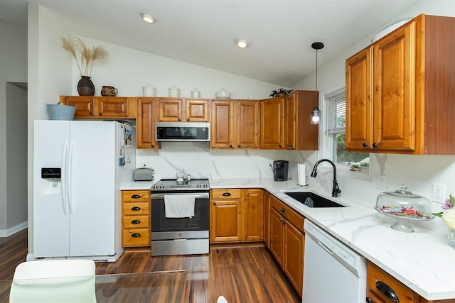 21 E Payton Ave, Des Moines, IA 50315 - kitchen featuring white appliances, dark wood finished floors, lofted ceiling, brown cabinets, and hanging light fixtures