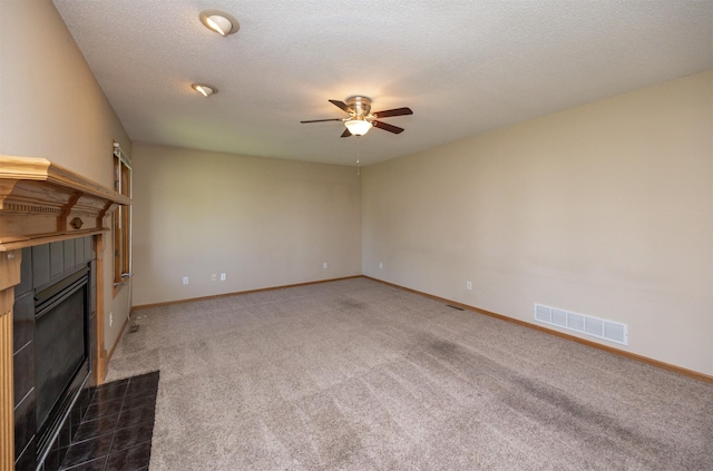7523 Aspen Dr, West Des Moines, IA 50266 - unfurnished living room featuring a tiled fireplace, a ceiling fan, and carpet