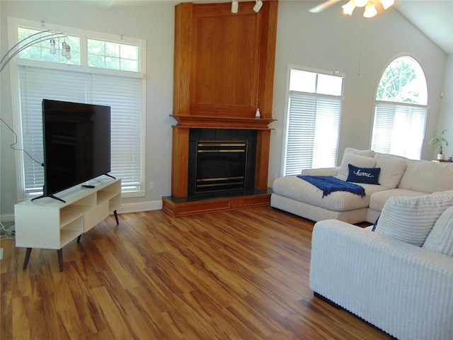 8114 Cobblestone Ct, Urbandale, IA 50322 - living room with a fireplace, wood finished floors, ceiling fan, and vaulted ceiling