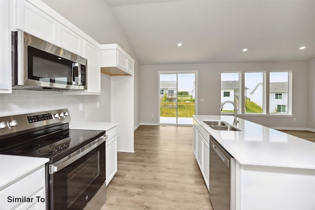605 NW Compass Ave, Waukee, IA 50263 - kitchen featuring stainless steel appliances, decorative backsplash, light countertops, white cabinetry, and light wood-style flooring