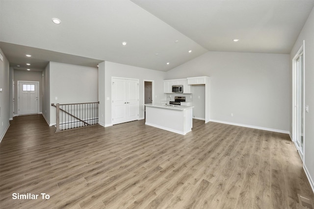 1163 NW Petersen Dr, Waukee, IA 50263 - unfurnished living room featuring lofted ceiling, light wood-type flooring, and recessed lighting