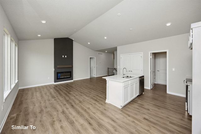 1163 NW Petersen Dr, Waukee, IA 50263 - kitchen with stainless steel dishwasher, open floor plan, light wood-type flooring, a fireplace, and white cabinetry