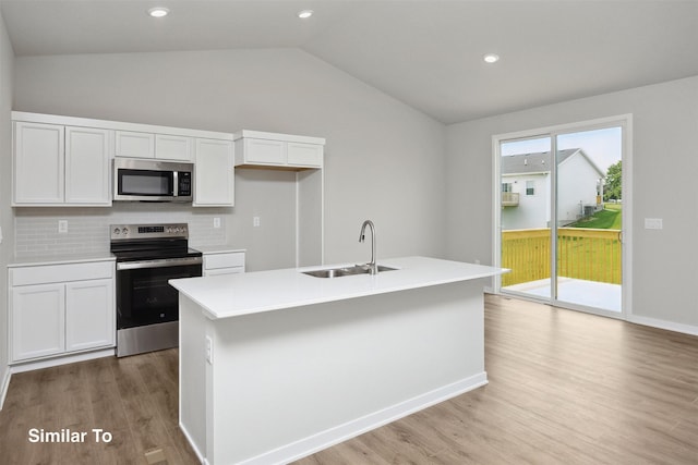 1163 NW Petersen Dr, Waukee, IA 50263 - kitchen with appliances with stainless steel finishes, vaulted ceiling, light wood-style floors, white cabinetry, and backsplash