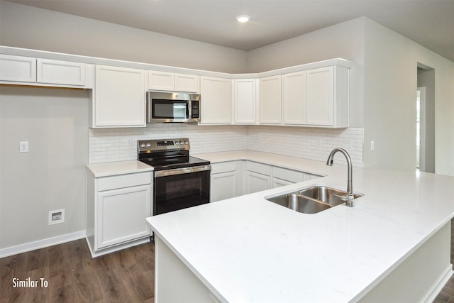 9756 Regatta Ln, Johnston, IA 50131 - kitchen with stainless steel appliances, a peninsula, dark wood-style flooring, white cabinets, and recessed lighting