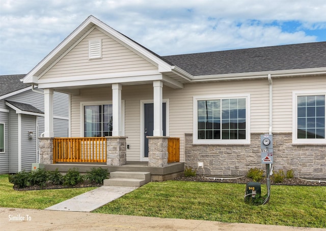 9764 Regatta Ln, Johnston, IA 50131 - view of front of home featuring stone siding, a front yard, and covered porch