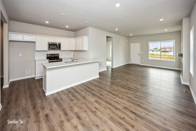 9764 Regatta Ln, Johnston, IA 50131 - kitchen featuring stainless steel microwave, range with electric stovetop, white cabinetry, decorative backsplash, and dark wood-style flooring
