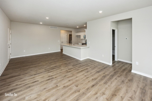 9764 Regatta Ln, Johnston, IA 50131 - unfurnished living room with wood finished floors and recessed lighting