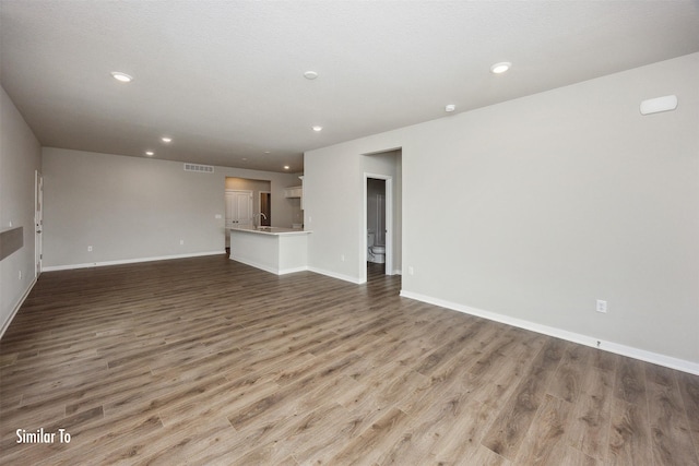 9764 Regatta Ln, Johnston, IA 50131 - unfurnished living room with wood finished floors and recessed lighting